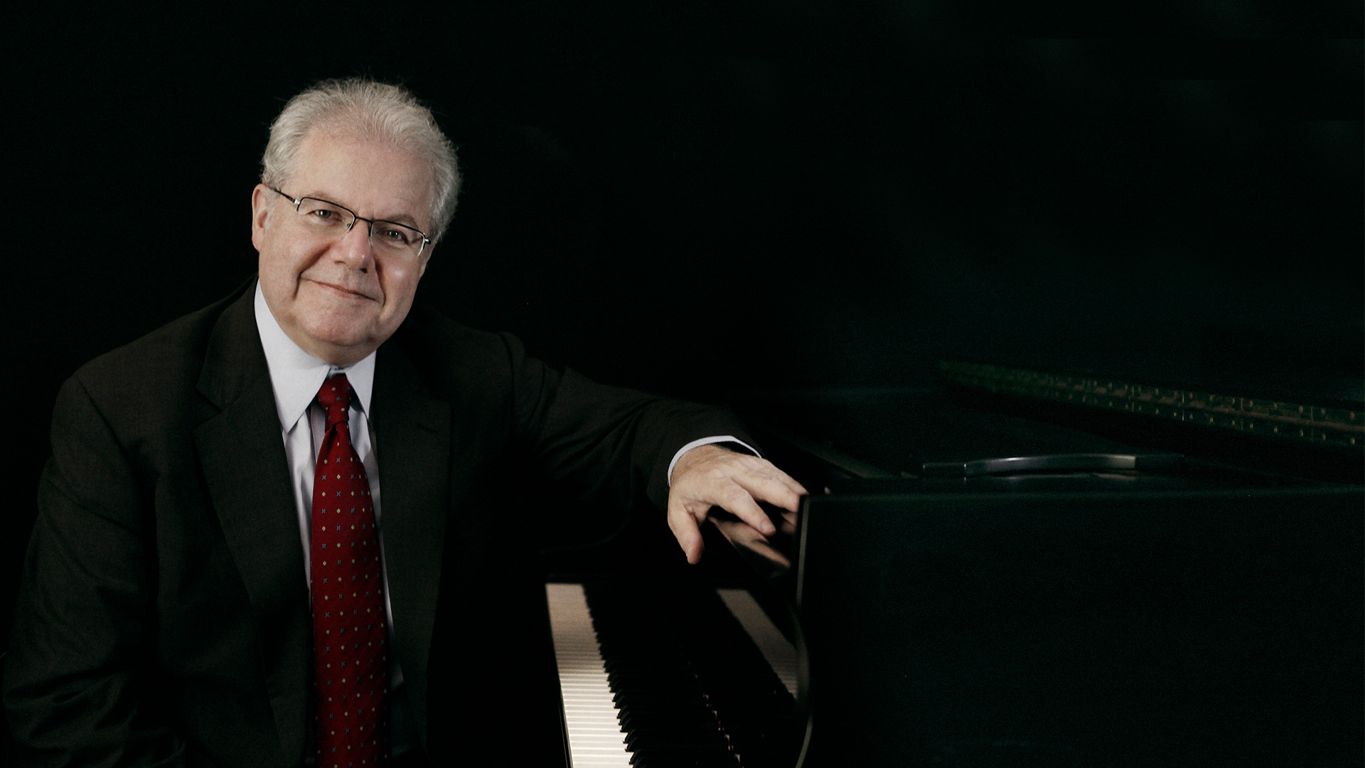 A man sitting next to a piano