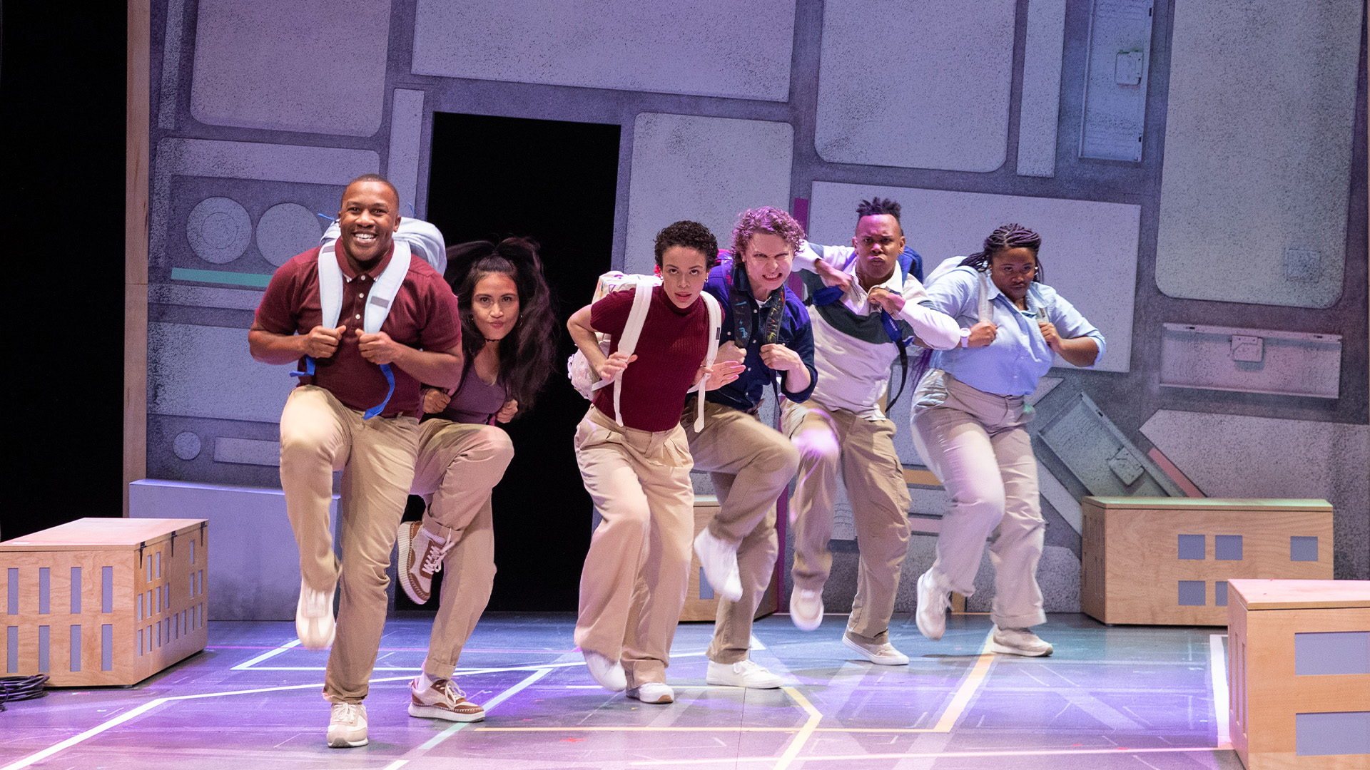 A group of students wearing backpacks dancing