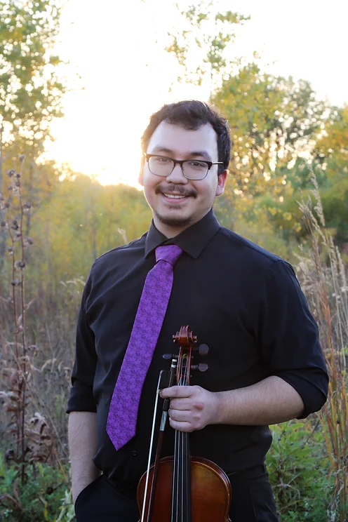 Julian Perez holding violia in a field