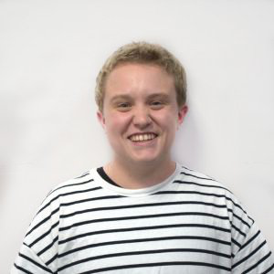 A young man with curly blond hair in a white striped shirt