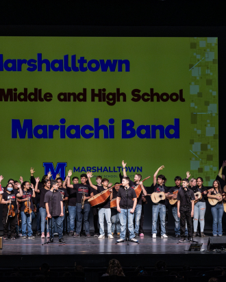 Students on stage holding instruments 123Andres