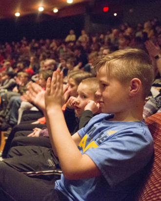 Child clapping in the Great Hall