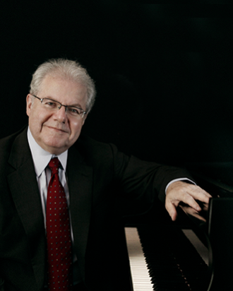 A man sitting next to a piano