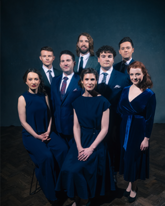 A group of people in suits and dresses posing for a portrait