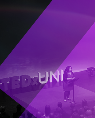 A purple background with a woman speaking on a stage